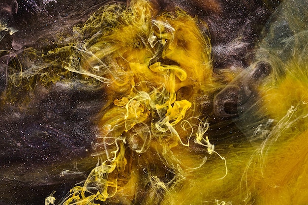 Fundo abstrato amarelo preto do oceano Salpicos e ondas de tinta sob nuvens de água de fumaça interestelar em movimento