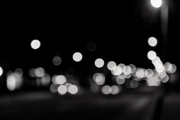 Fundo abstrato bokeh de rua à noite com carro e lâmpadas de rua. vida na cidade, luzes desfocadas da paisagem urbana, tons de cores de estilo. conceito de fundos urbanos elegantes abstratos para o projeto. copie o espaço