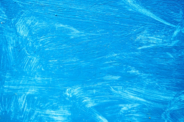 Fundo abstrato com traços texturizados de tinta azul na superfície de madeira