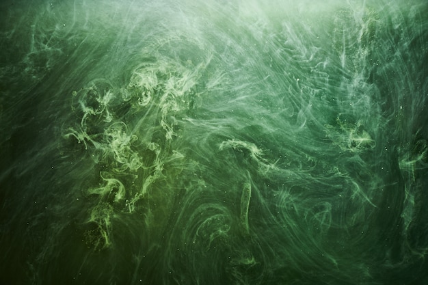 Fundo abstrato da cor verde. Circulando fumaça vibrante de narguilé, oceano esmeralda subaquático, pintura dinâmica na água