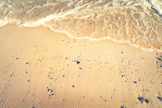 Fundo abstrato do mar de verão. praia de areia dourada com ondas oceânicas. espaço livre