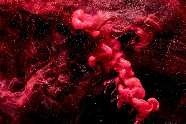 Fundo abstrato vermelho do oceano salpicos e ondas de tinta sob nuvens de água de fumaça em movimento