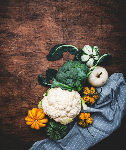 Foto fundo alimentar com abóboras de brócolis de couve-flor do mercado agrícola local na velha mesa de madeira rústica compras alimentação saudável conceito de comida limpa