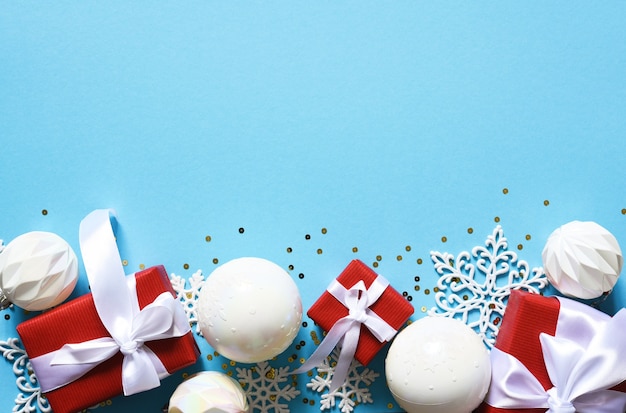 Fundo azul delicado de Natal com bolas brancas. Luzes de bokeh. Decoração de ano novo. Presentes.
