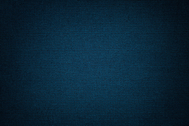 Foto fundo azul escuro de um material têxtil. tecido com textura natural. pano de fundo.