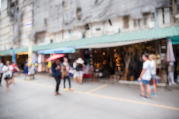 Fundo borrado: as pessoas que fazem compras na feira do mercado no dia ensolarado, desfocam o fundo com bokeh