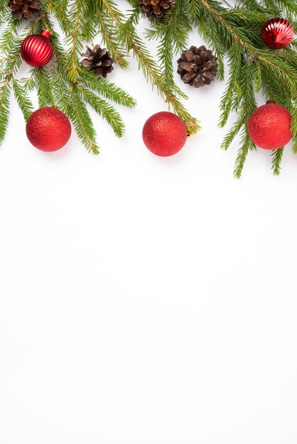 Fundo branco de Natal com um galho de pinheiro, cones e bolas de pinheiro, vista de cima plana, cópia espaço