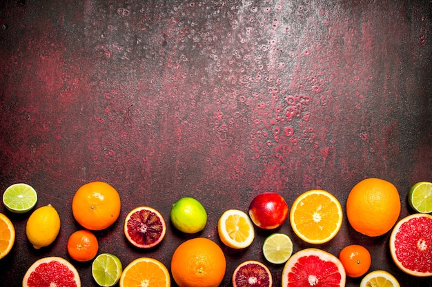 Foto fundo cítrico. frutas cítricas . sobre fundo vermelho rústico.
