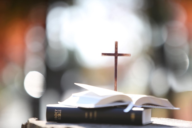 Fundo claro brilhante da igreja com a bíblia sagrada e a cruz da salvação de Jesus Cristo