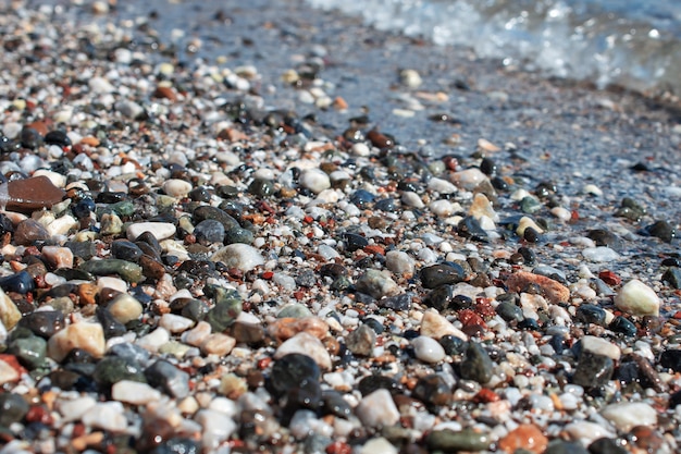 Fundo colorido das pedras da praia. seixos multicoloridos na praia, lavados pelas ondas