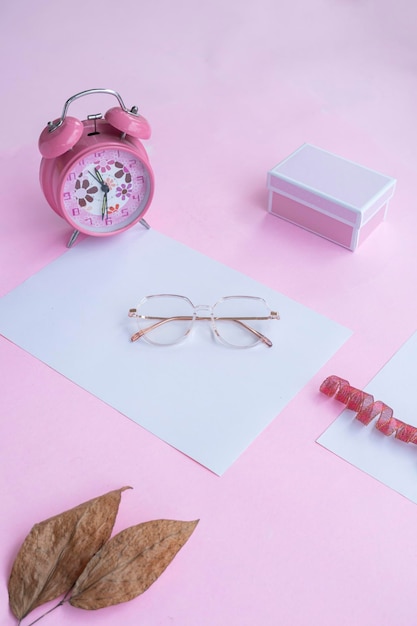 Fundo colorido de verão com óculos de moda relógio caixa de presente folhas secas O conceito de férias de moda de verão estava plano Foto vertical de fundo rosa