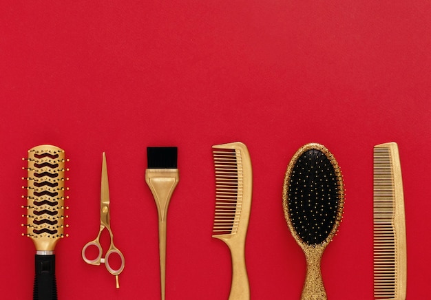Fundo com ferramentas de cabeleireiro em vermelho Acessórios de salão de cabeleireiro ouro pentes tesouras Banner e modelo para design com espaço para texto