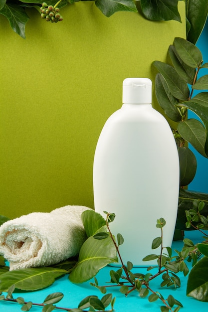 Fundo com folhas e plantas verdes e frasco de cosmético. Conceito de cuidado natural da pele