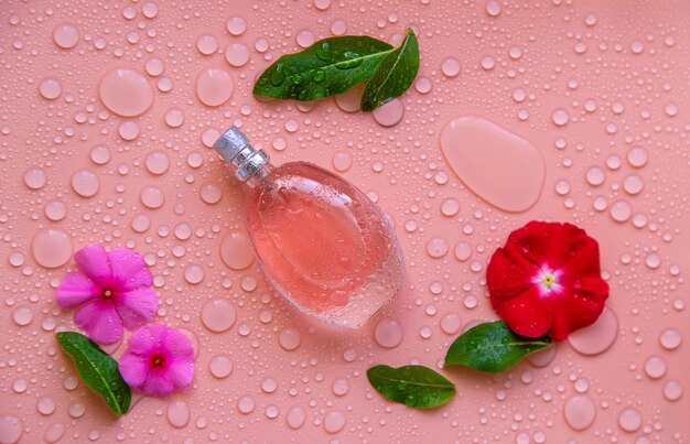 Fundo com gotas de água de perfume e flores Foco seletivo