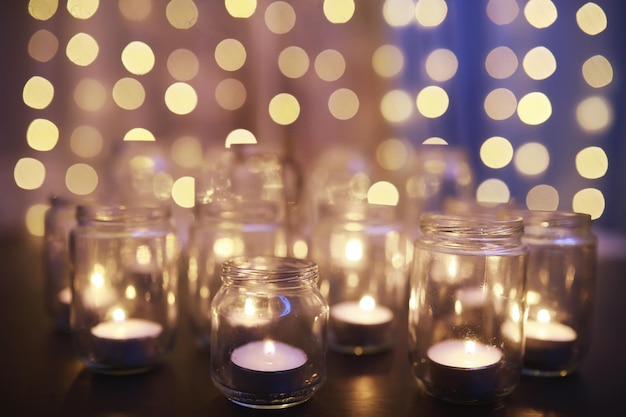 Fundo com velas em vasos de vidro velas queimam em um lugar escuro descanse em paz