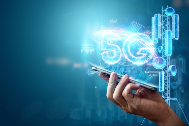 Fundo criativo, a mão de um homem segura um telefone com um holograma 5G no fundo da cidade. Conceito de rede 5G, internet móvel de alta velocidade, redes de nova geração. Mídia mista.