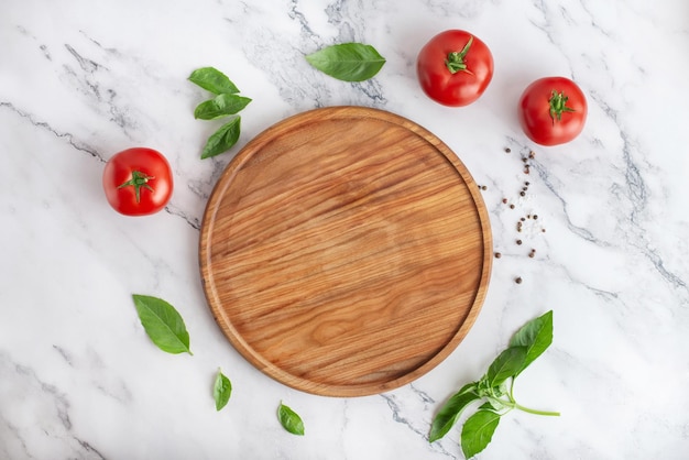 fundo culinário para cozinhar pizza Tábua de madeira e legumes na mesa branca