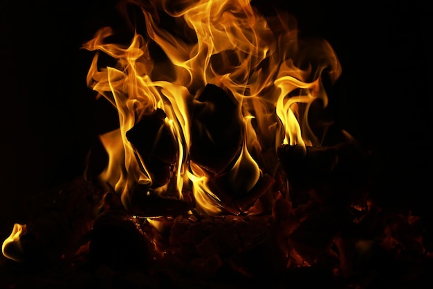 Fundo da chama no forno Línguas de fogo em uma lareira de tijolos Textura de fogo