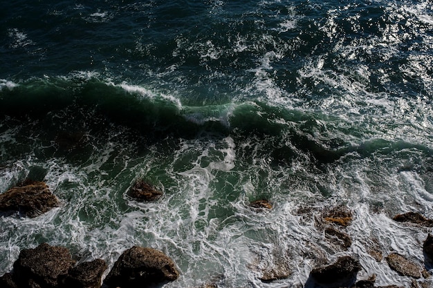 Fundo da onda do oceano quebrando a costa rochosa da água do mar