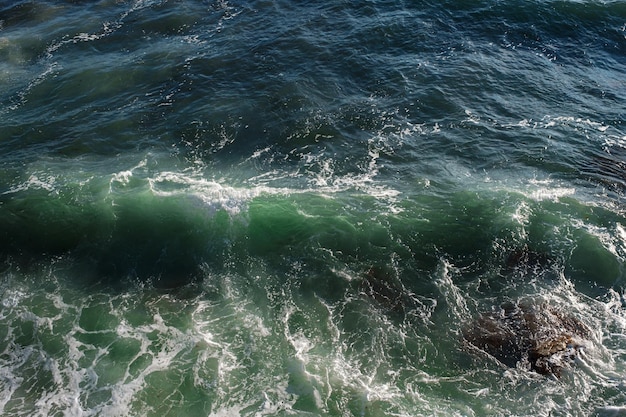 Fundo da onda do oceano quebrando a costa rochosa da água do mar