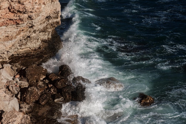 Fundo da onda do oceano quebrando a costa rochosa da água do mar