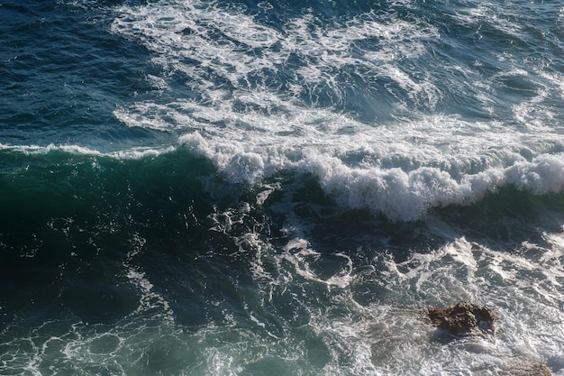 Fundo da onda do oceano quebrando a costa rochosa da água do mar