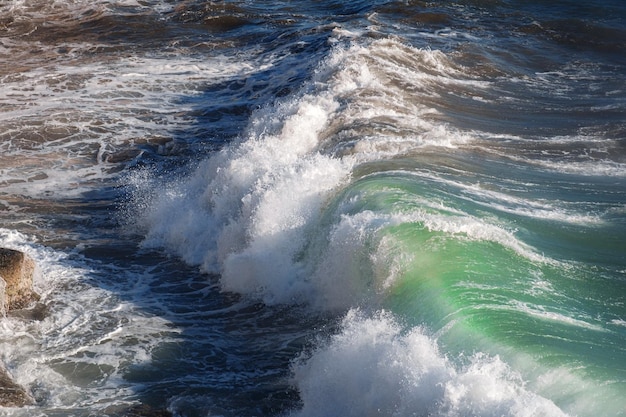 Foto fundo da onda do oceano quebrando a costa rochosa da água do mar