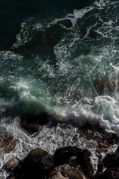 Fundo da onda do oceano quebrando a costa rochosa da água do mar