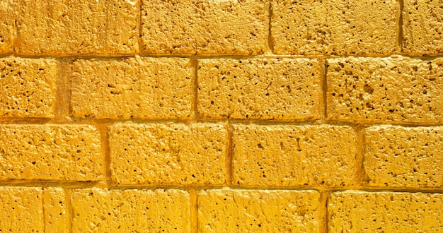 Fundo da textura do sumário da parede de tijolo do ouro.
