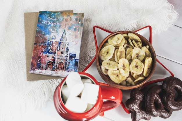 Fundo da véspera de Ano Novo Caneca de Papai Noel com marshmallows biscoitos de Natal livro aberto