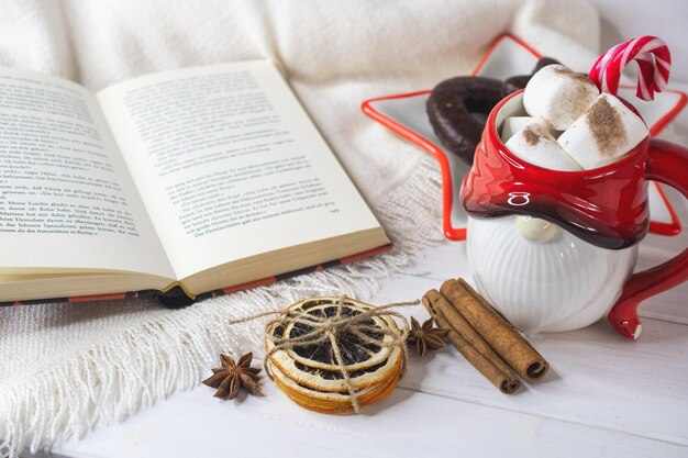 Fundo da véspera de Ano Novo Caneca de Papai Noel com marshmallows biscoitos de Natal livro aberto