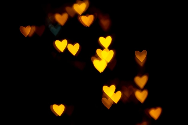 Fundo das luzes em forma de coração do grunge dos namorados. Ouro amarelo e azul em forma de coração em fundo preto Bokeh colorido de iluminação para decoração de dia dos namorados, fundo de imagens de amor