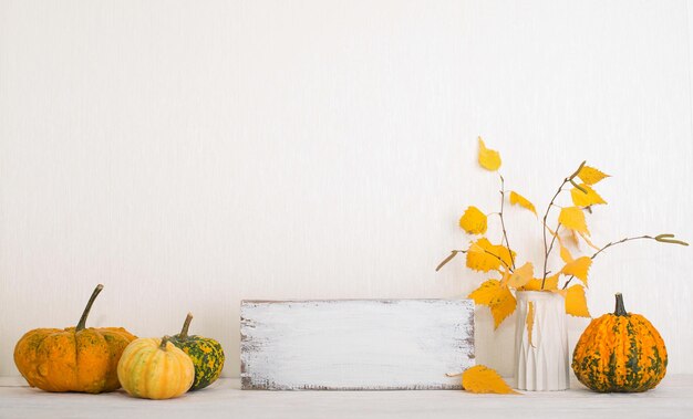 Foto fundo de ação de graças mockup com abóboras e folhas de outono sobre parede branca com copyspace