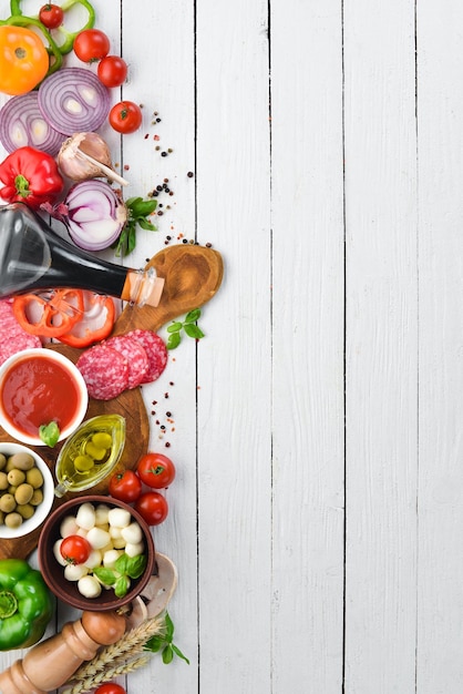 Fundo de alimentos Cogumelos queijo enchidos tomates legumes Vista superior Em um fundo de madeira Espaço para cópia grátis