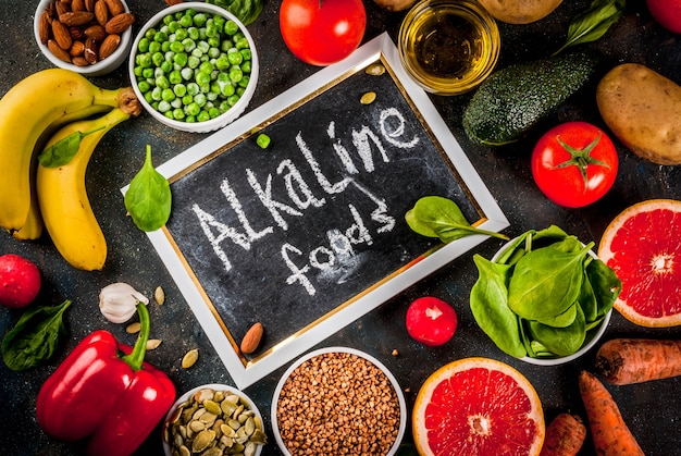 Fundo de alimentos saudáveis, produtos de dieta alcalina na moda - frutas, legumes, cereais, nozes. óleos, fundo de concreto azul escuro acima