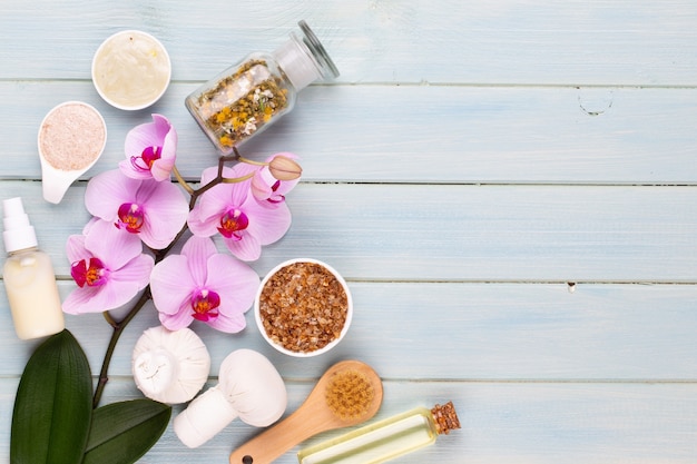 Fundo de aromaterapia de spa, postura plana de vários produtos de beleza, decorados com flores de orquídea simples.