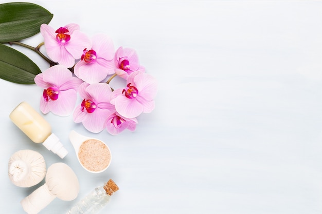 Fundo de aromaterapia de spa, postura plana de vários produtos de beleza decorados com flores de orquídea simples.