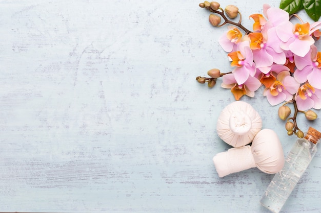 Foto fundo de aromaterapia de spa, postura plana de vários produtos de beleza, decorados com flores de orquídea simples.