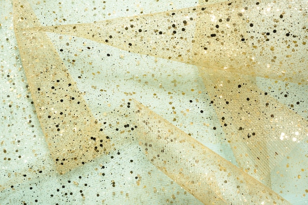Fundo de arte chique. Formas de cone em tecido transparente com glitter dourado em azul claro. Abstrato, feriado.