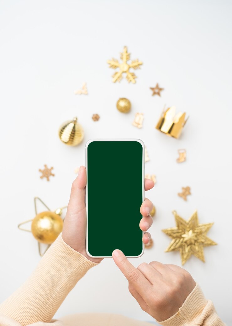 Foto fundo de banner de natal. mulher furando celular com tela em branco sobre o natal dourado na árvore de natal
