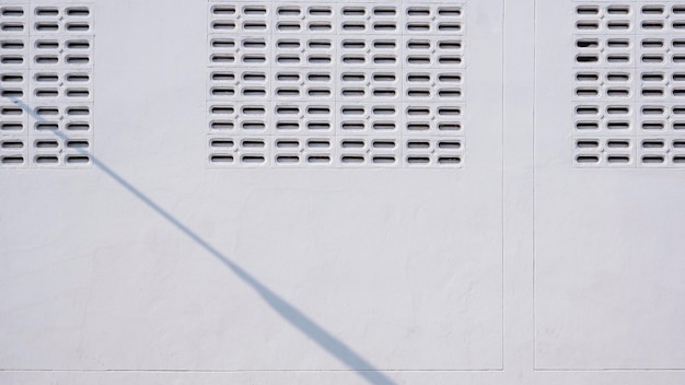 Fundo de blocos de ventilação na parede de armazenamento branca com sombra de lâmpada de parede de rua na superfície