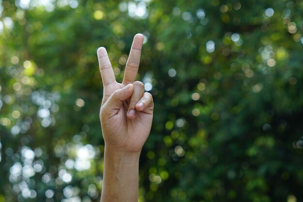 fundo de bokeh verde de mão humana de dois dedos