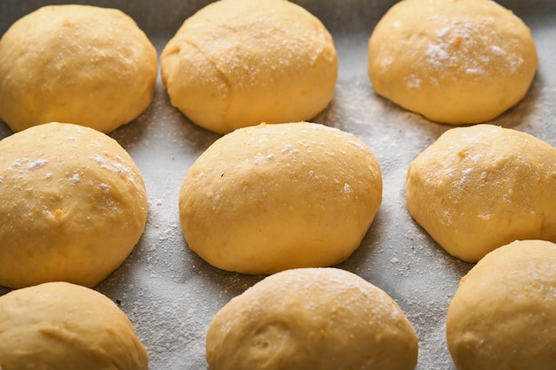 Fundo de bolas de massa de fermento cru na frigideira antes de assar. Conceito casa assando pão, pãezinhos ou cinnabon ou fazendo massa.