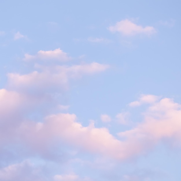 Fundo de céu azul com nuvens brancas e rosa ao pôr do sol
