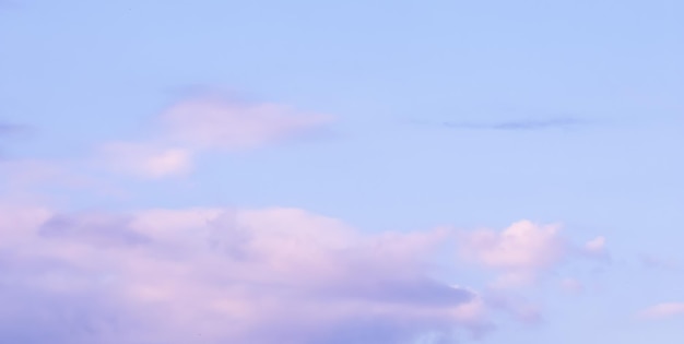 Fundo de céu azul com nuvens brancas e rosa ao pôr do sol