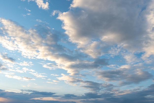 Fundo de céu azul com nuvens cumulus fofas iluminadas pelo sol poente Panorama de nuvens fofas brancas no céu azul Lindo céu azul vasto com incríveis nuvens cumulus espalhadas