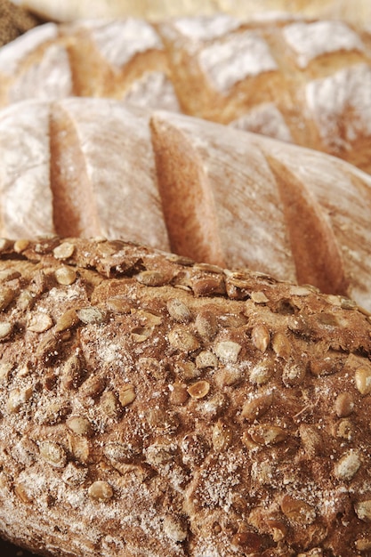 Fundo de closeup de crosta de textura de pão, pão de baguete fresco e pão de centeio com sementes de girassol