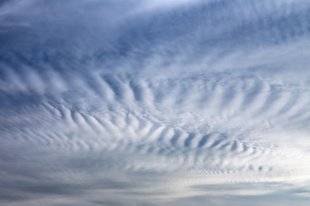 Fundo de cloudscape pitoresco com nuvens leves de spindrift em um céu azul escuro