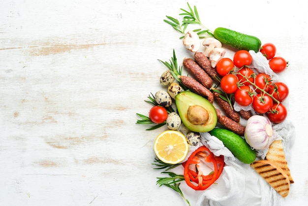 Fundo de comida de madeira branca tomates massas especiarias legumes e salsichas Vista superior