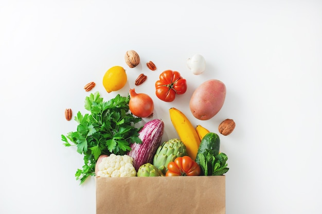 Fundo de comida saudável. comida vegetariana vegana saudável em vegetais de saco de papel e frutas em branco, copie o espaço. supermercado de alimentos de compras e conceito de alimentação vegana limpa.